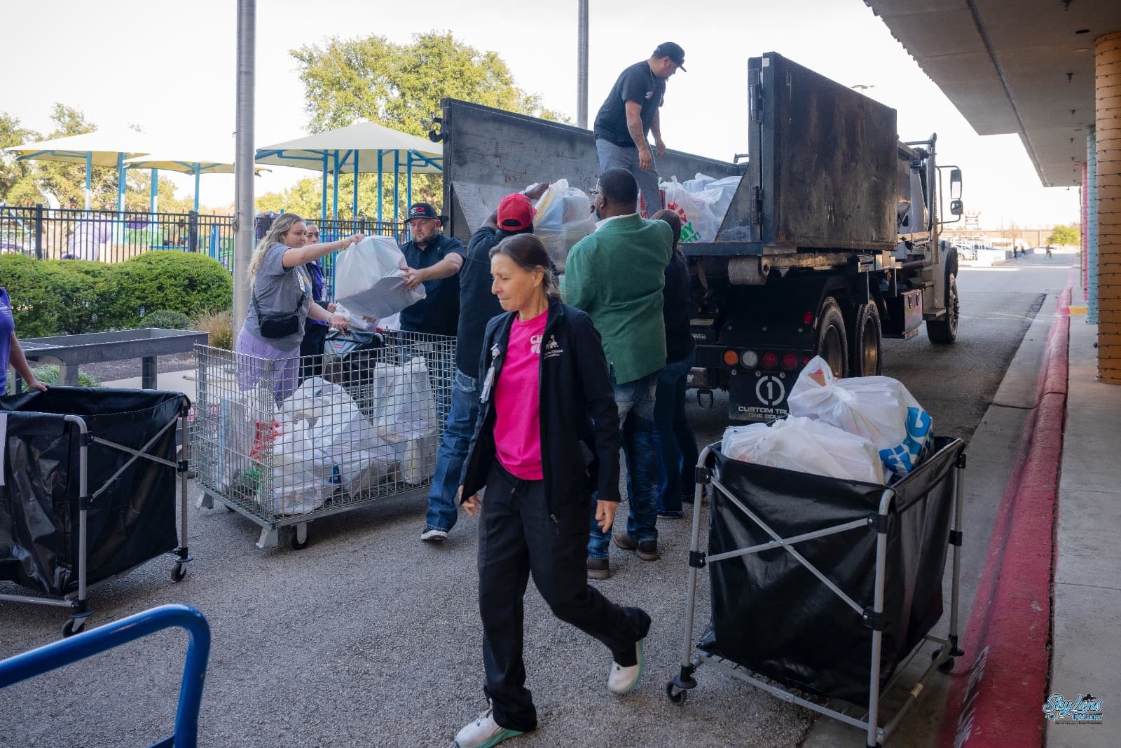 S&P Dumpsters crew and volunteers unloading donation bags from a company truck