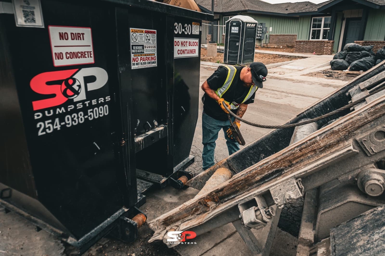 A crew member loading lumber into an S&P container